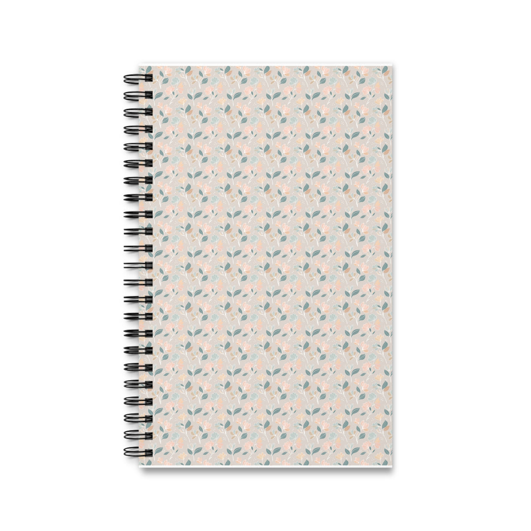 A spiral-bound notebook with a light beige cover decorated in a delicate repeating pattern of small blue leaves and pink flowers, bound with a black metal spiral on a white background.