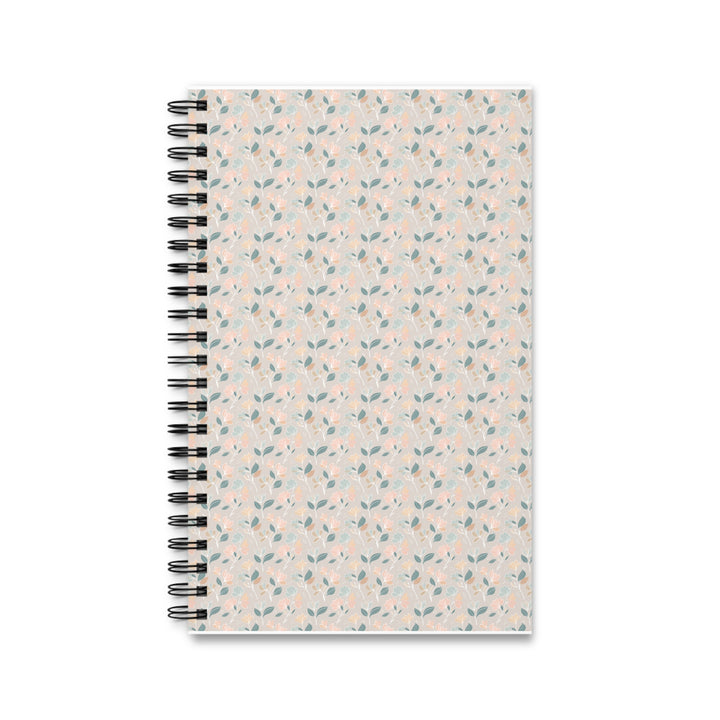 A spiral-bound notebook with a light beige cover decorated in a delicate repeating pattern of small blue leaves and pink flowers, bound with a black metal spiral on a white background.
