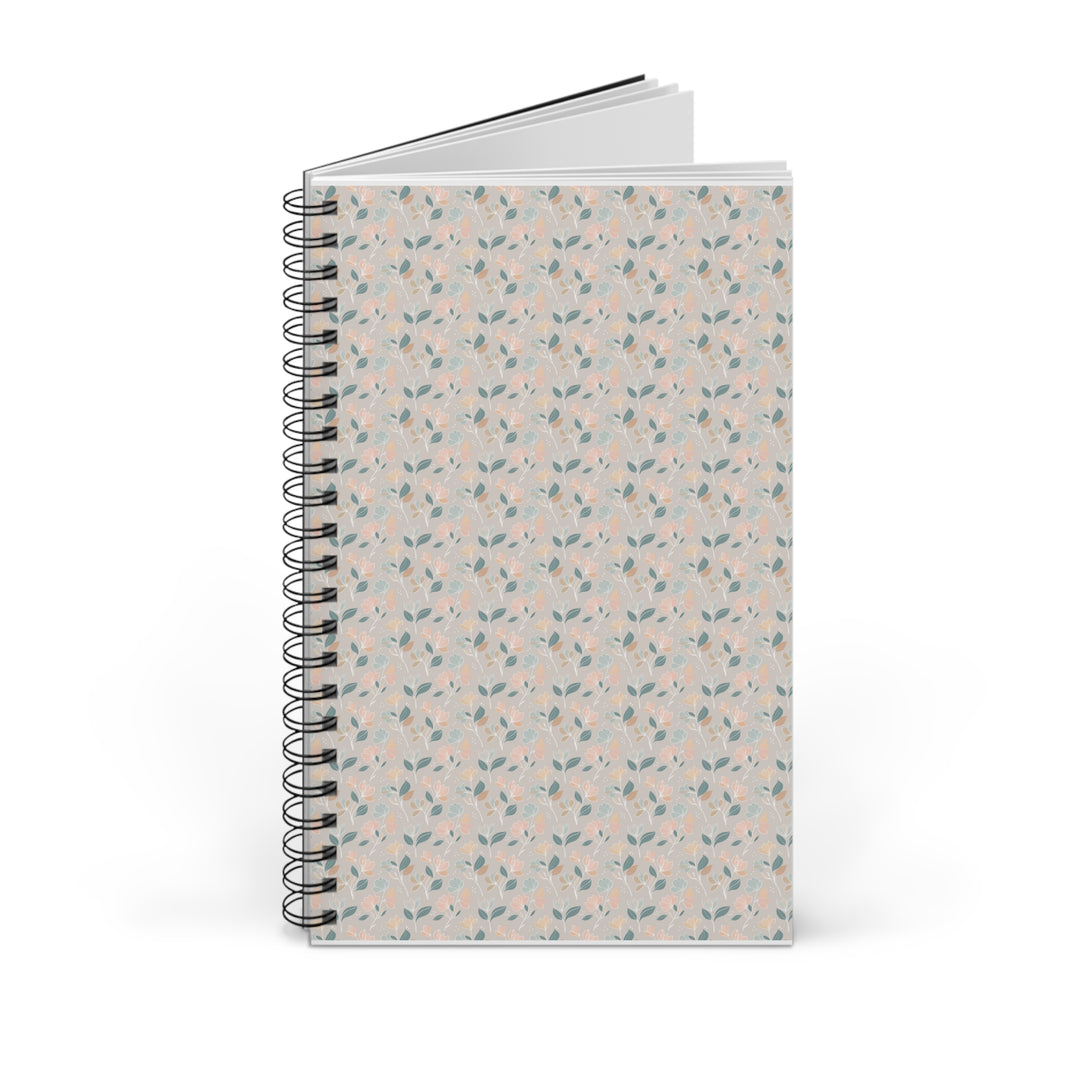 A spiral-bound notebook with a light beige cover decorated in a delicate repeating pattern of small pink flowers and green leaves, shown on a clean white background.
