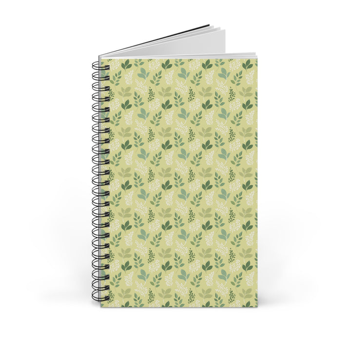A spiral-bound notebook with a light green cover featuring a repeating pattern of darker green leaves, shown on a plain white background.