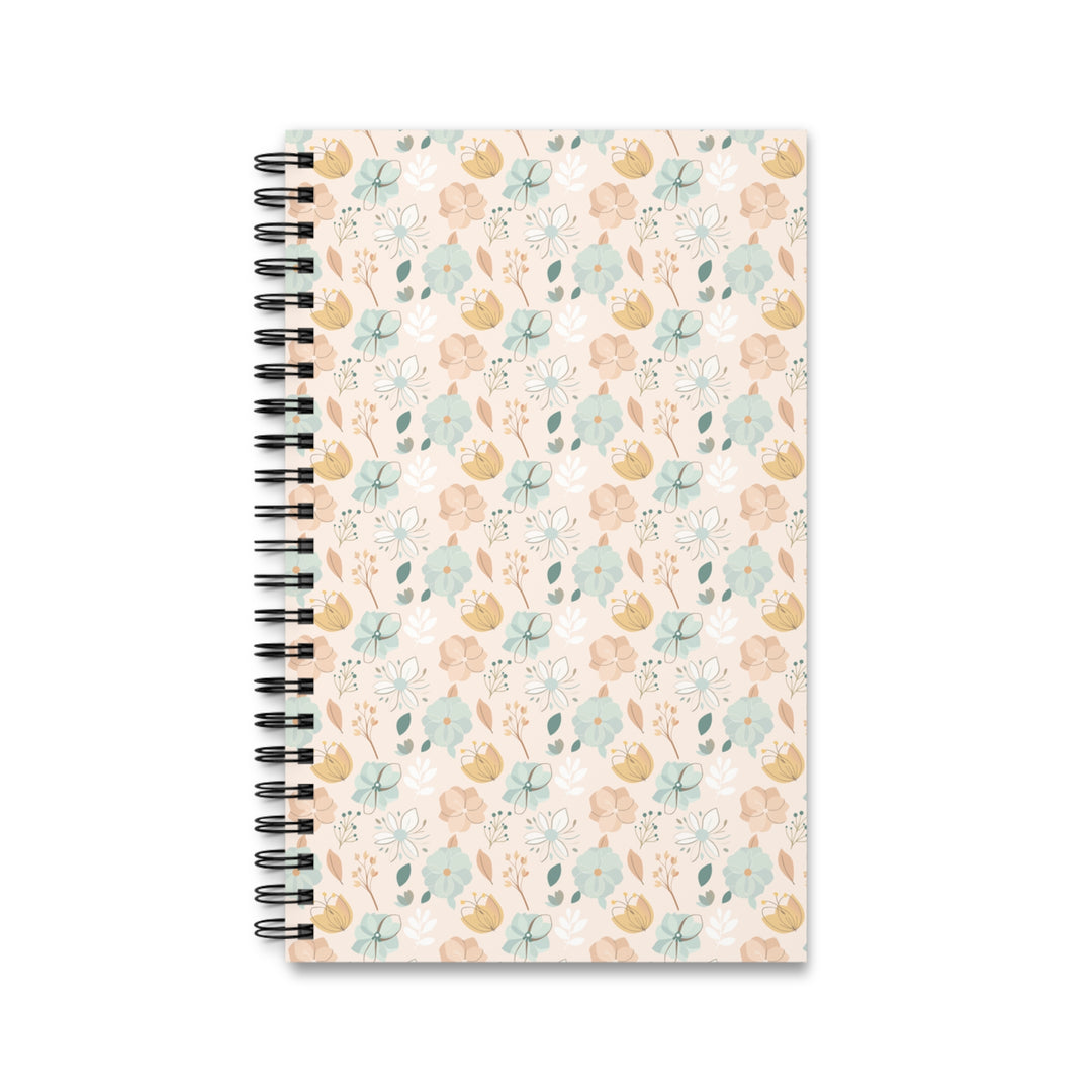 A spiral-bound notebook with a pastel floral pattern on a cream cover, shown against a plain white background.