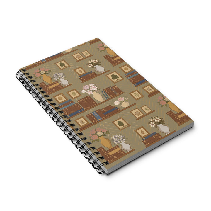 A spiral-bound notebook with a vintage-style bookshelf pattern on the cover, shown at an angle on a white background.