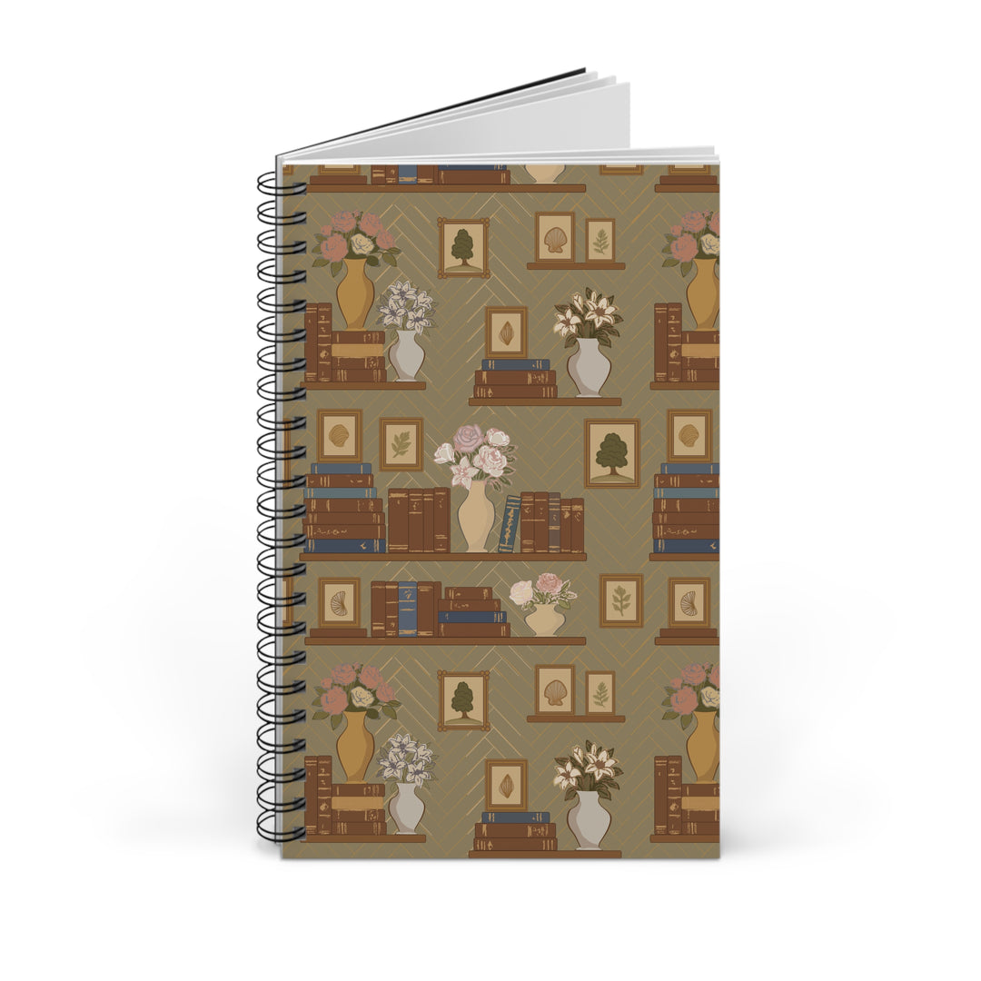 A spiral-bound notebook with a vintage bookshelf pattern on the cover, featuring brown shelves, books, vases with flowers, and framed pictures on a muted olive background.