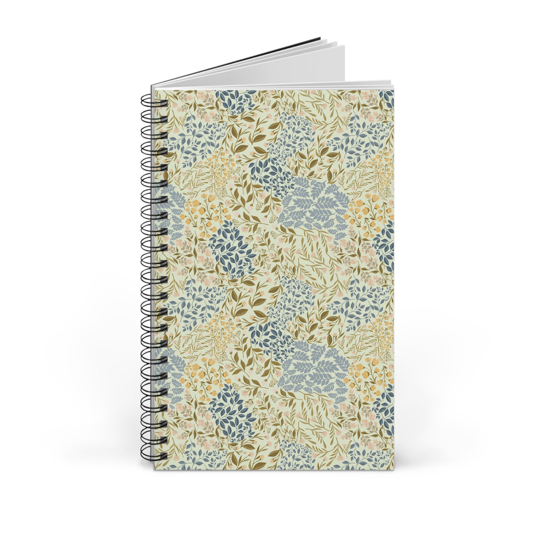A spiral-bound notebook with a vintage botanical pattern cover, featuring blue, green, and yellow floral motifs on a cream background, shown on a white background.
