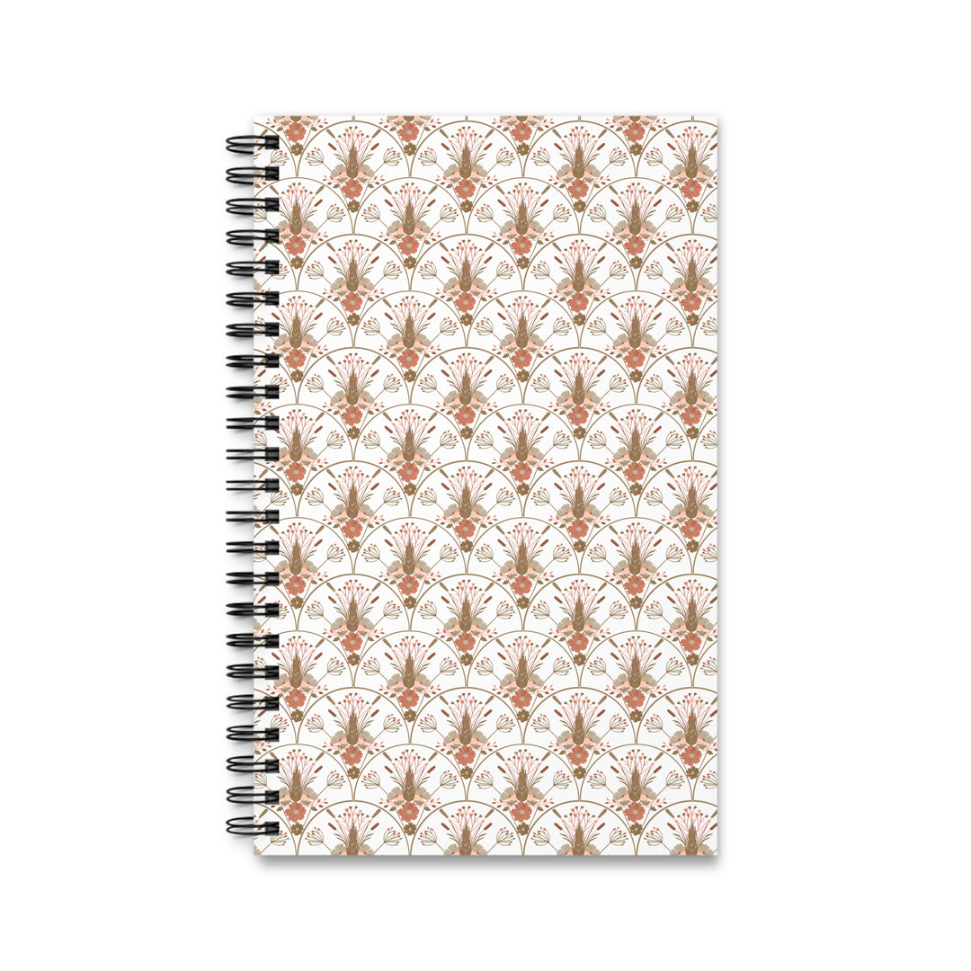A spiral-bound notebook with a white cover featuring a repeating ornate damask pattern in muted terracotta and taupe, bound with a black metal spiral on a white background.