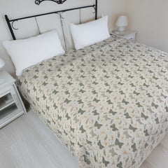 Bed with butterfly patterned duvet cover in a bedroom setting