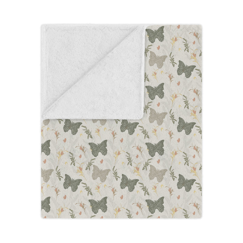 Butterfly patterned blanket with white border on a light gray background