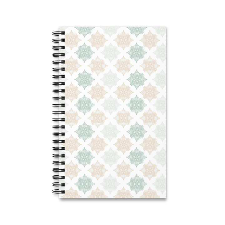 A spiral-bound notebook with a white cover featuring a repeating geometric pattern in soft sage green, beige, and light gray, bound with a black wire coil on a white background.