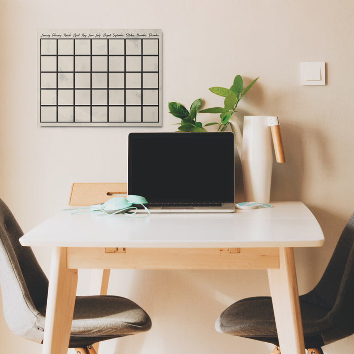 Dry erase reusable metal wall calendar on home office wall
