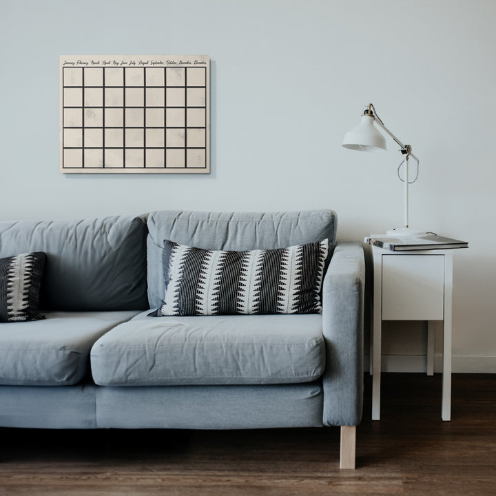Dry erase reusable metal wall calendar on comfy couch wall