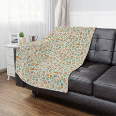 Floral patterned blanket draped over a gray sofa in a living room setting.
