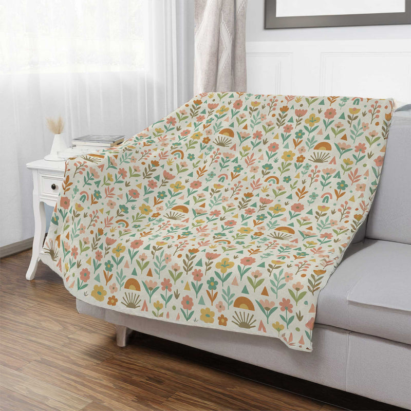 Floral patterned blanket draped over a sofa in a living room.