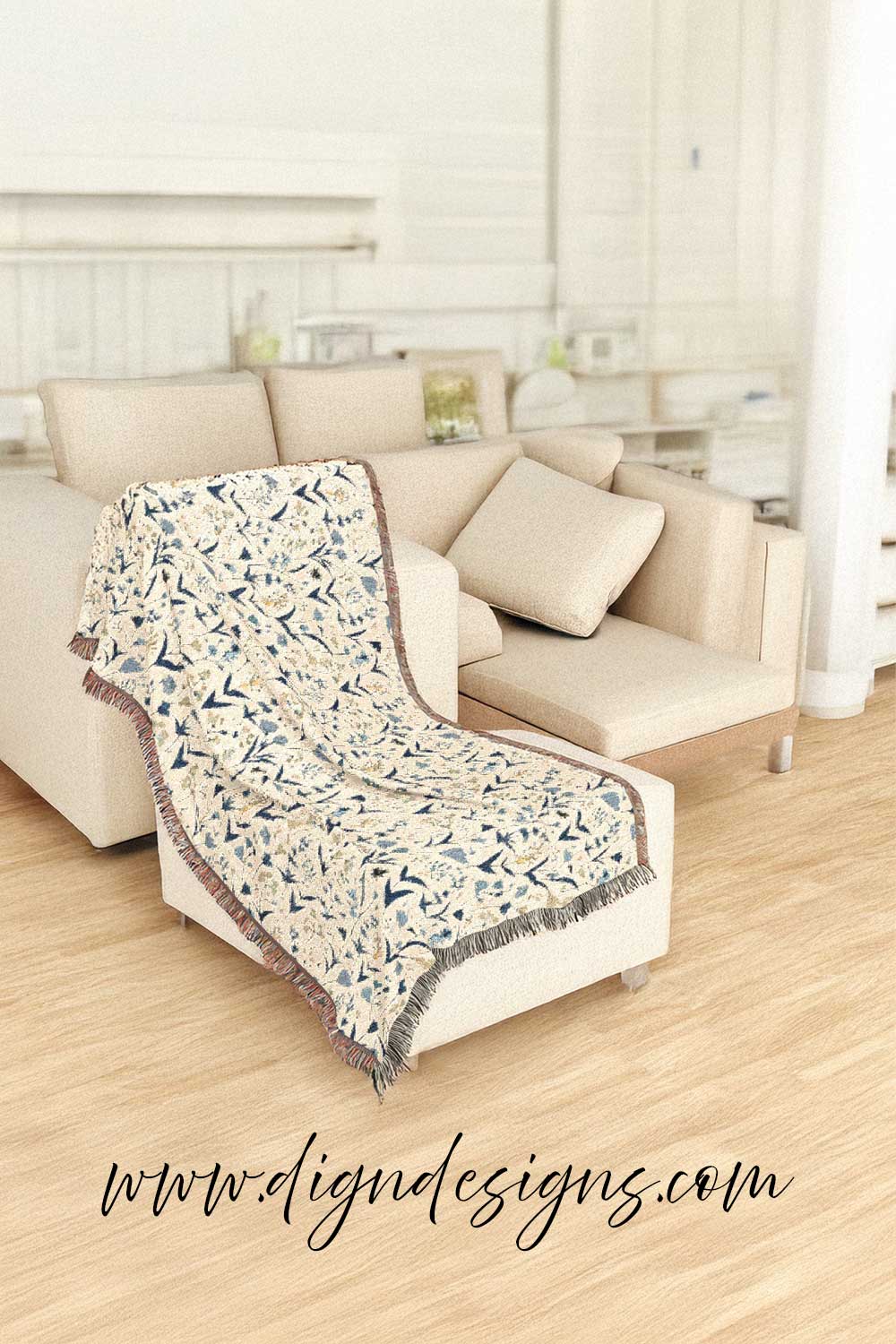 Floral patterned throw blanket draped over a beige sofa in a living room.