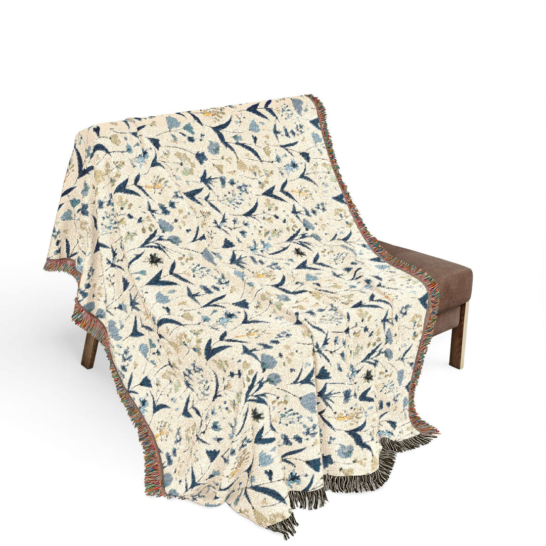 Floral patterned throw blanket draped over a chair on a white background
