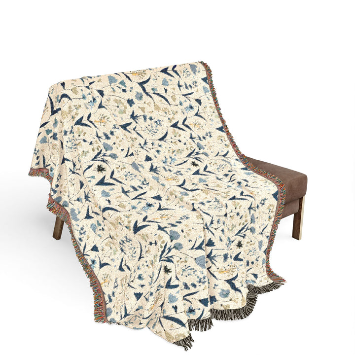 Floral patterned throw blanket draped over a chair on a white background