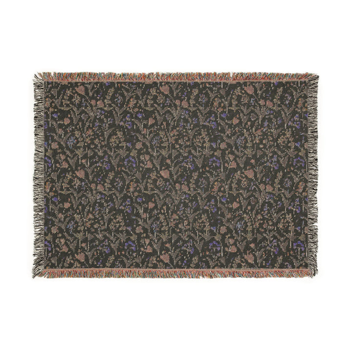 Floral patterned throw blanket with fringe on a white background