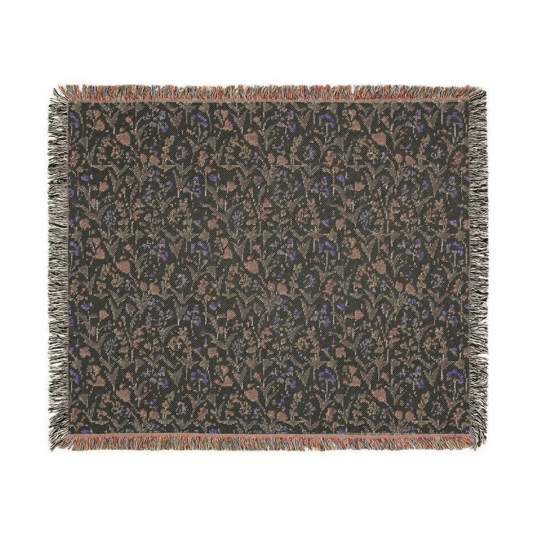 Floral patterned throw blanket with fringe on a white background