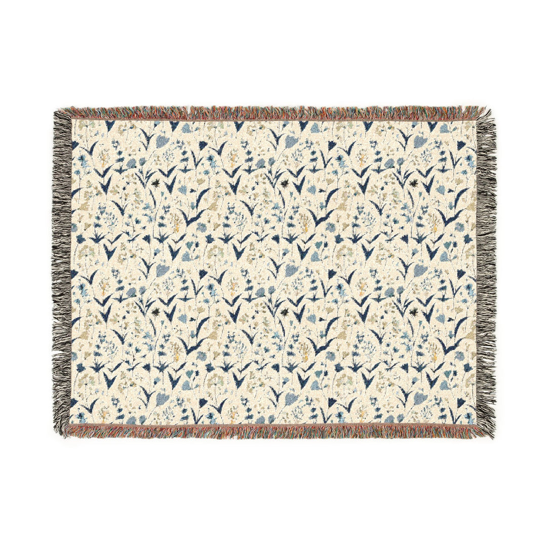 Floral patterned throw blanket with tassels on a white background