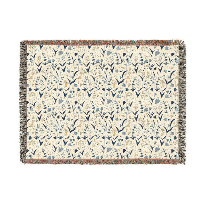 Floral patterned throw blanket with tassels on a white background