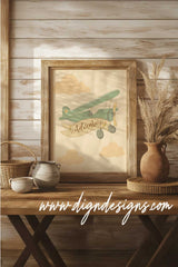 Framed artwork of a vintage airplane with 'Adventure' on a wooden table against a wooden wall.