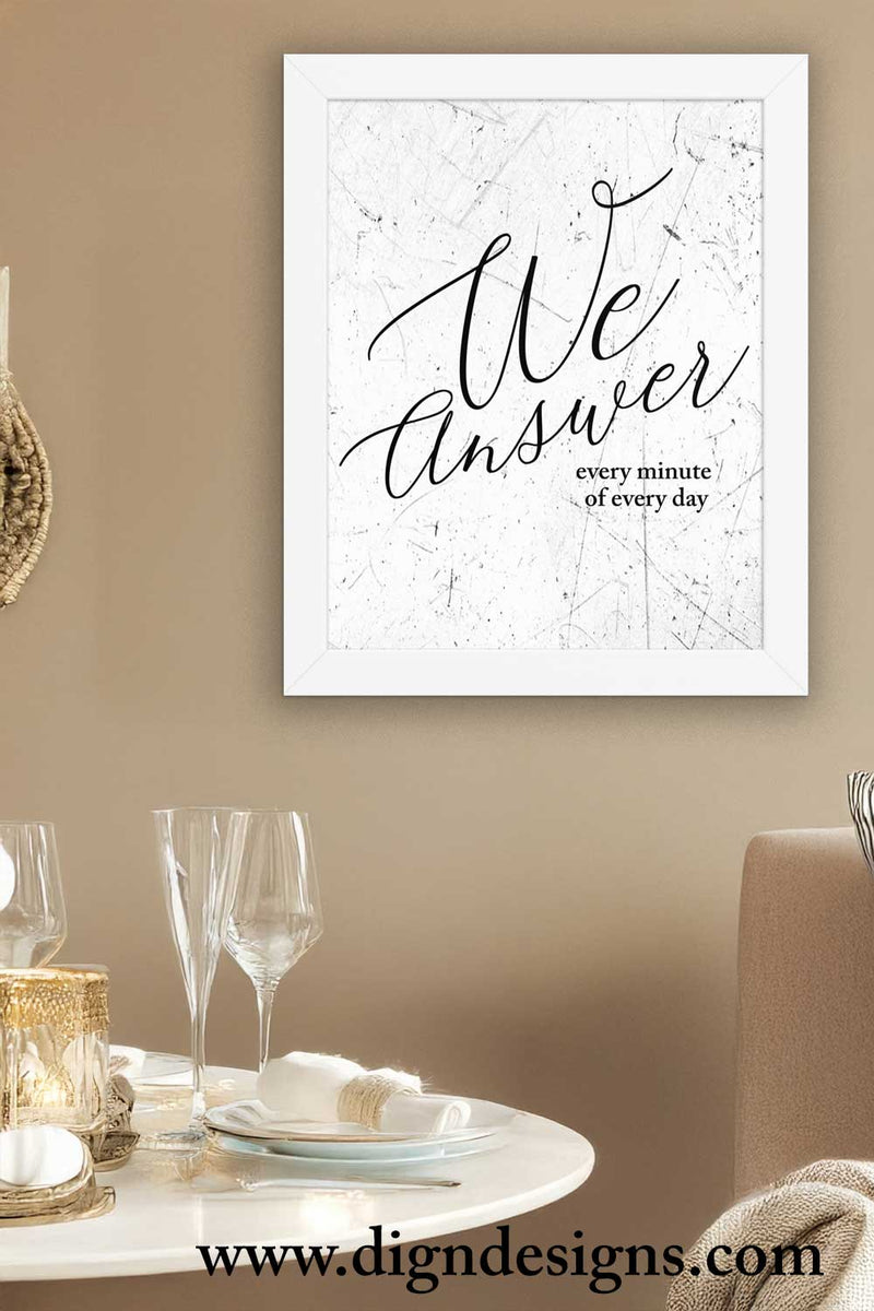 Framed artwork with 'We Answer every minute of every day' text in a dining room setting.