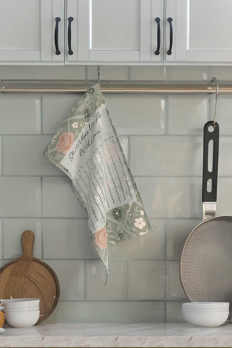 Kitchen scene with a floral-patterned towel hanging on a rack, surrounded by kitchen utensils and decor.