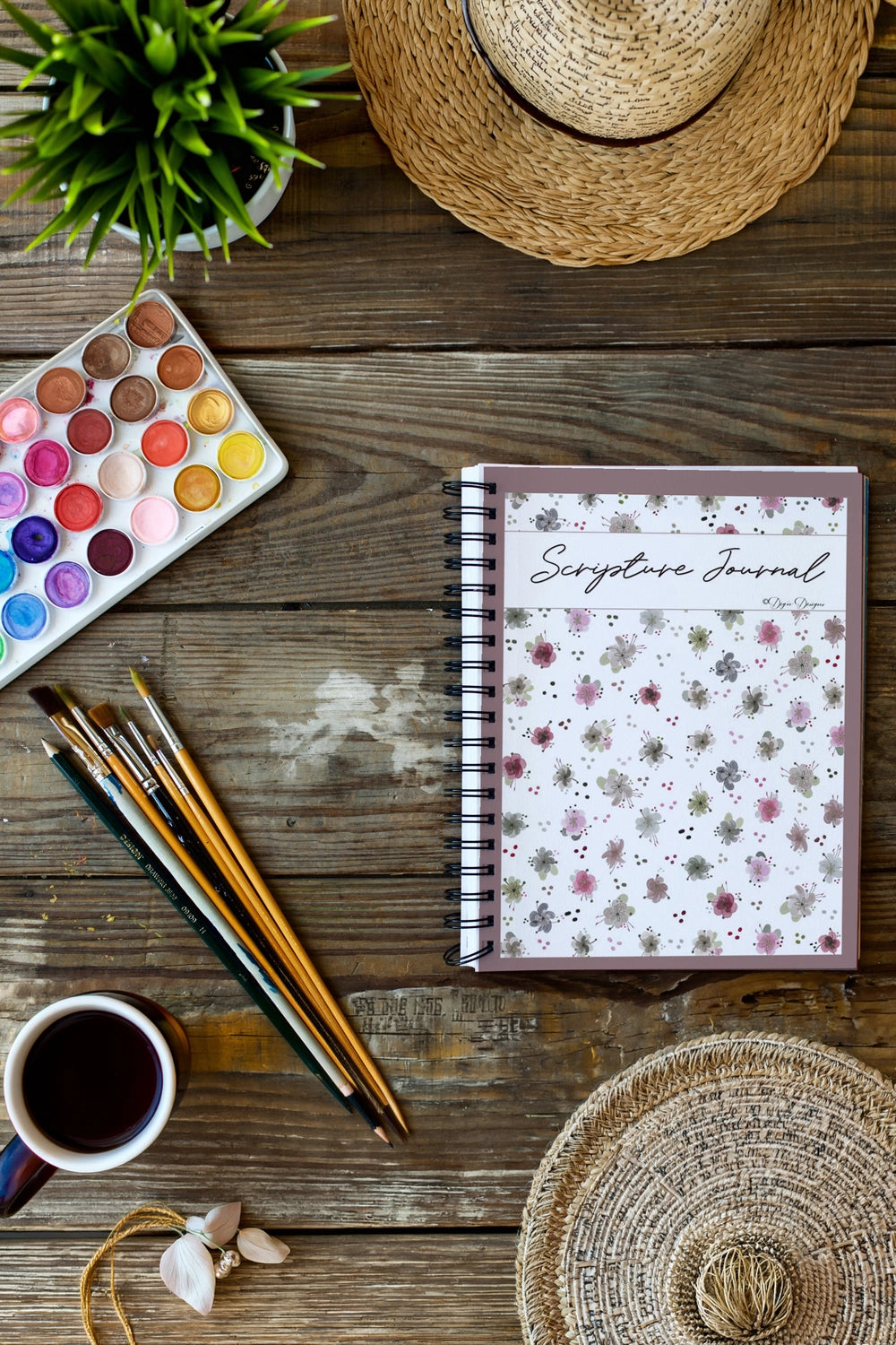 Notebook titled 'Scrapbook Journal' with art supplies on a wooden surface