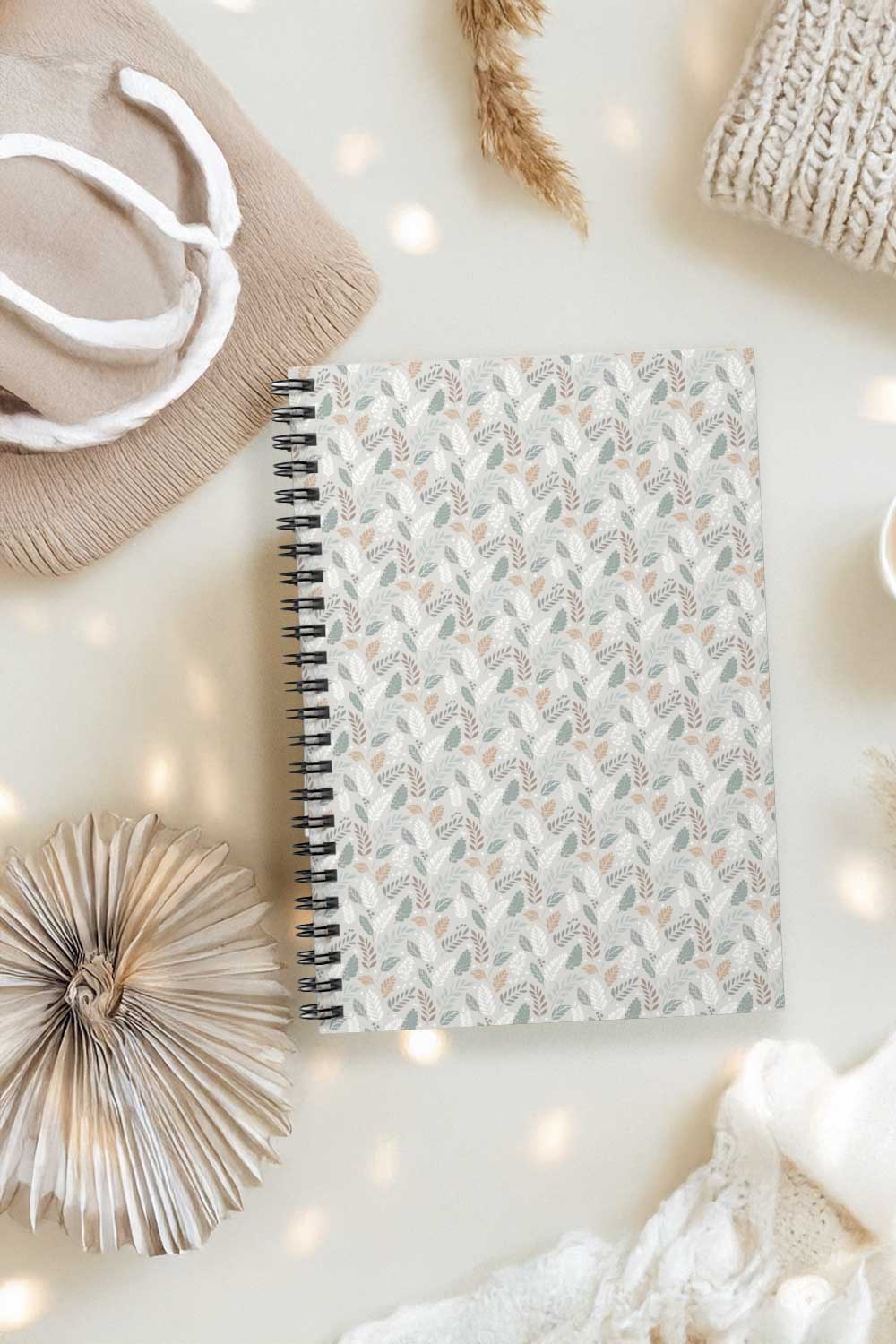 Notebook with floral pattern on a light surface with decorative items