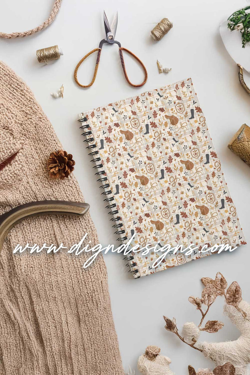 Notebook with floral pattern surrounded by knitting materials on a light background