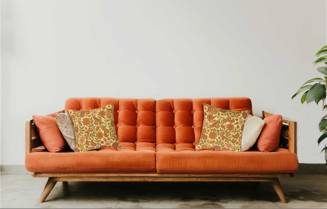 Orange sofa with patterned cushions against a white wall