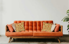 Orange sofa with patterned cushions against a white wall
