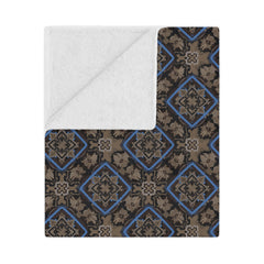 Patterned blanket with blue and brown design on a white background