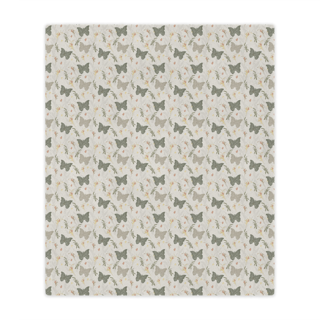 Patterned blanket with small butterfly illustrations on a light background