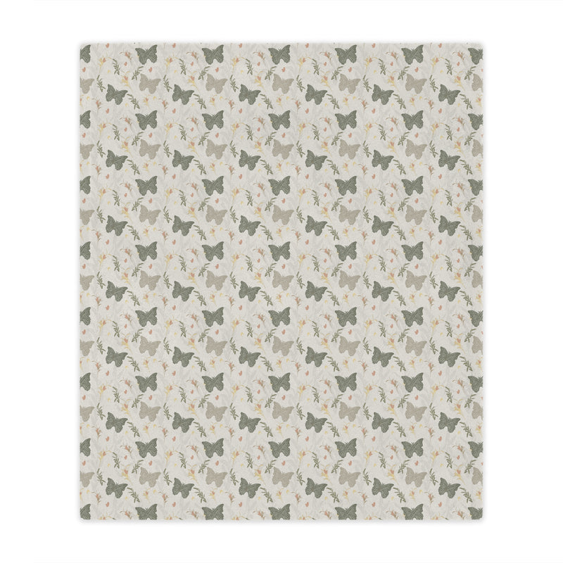 Patterned blanket with small butterfly illustrations on a light background