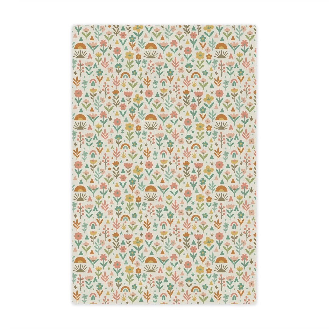 Patterned fabric with small floral and geometric designs on a light background