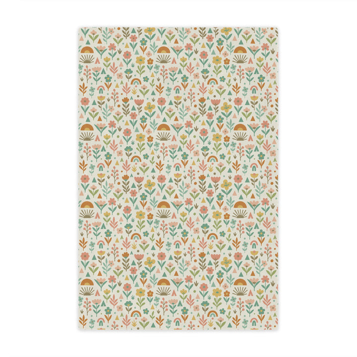 Patterned fabric with small floral and geometric designs on a light background