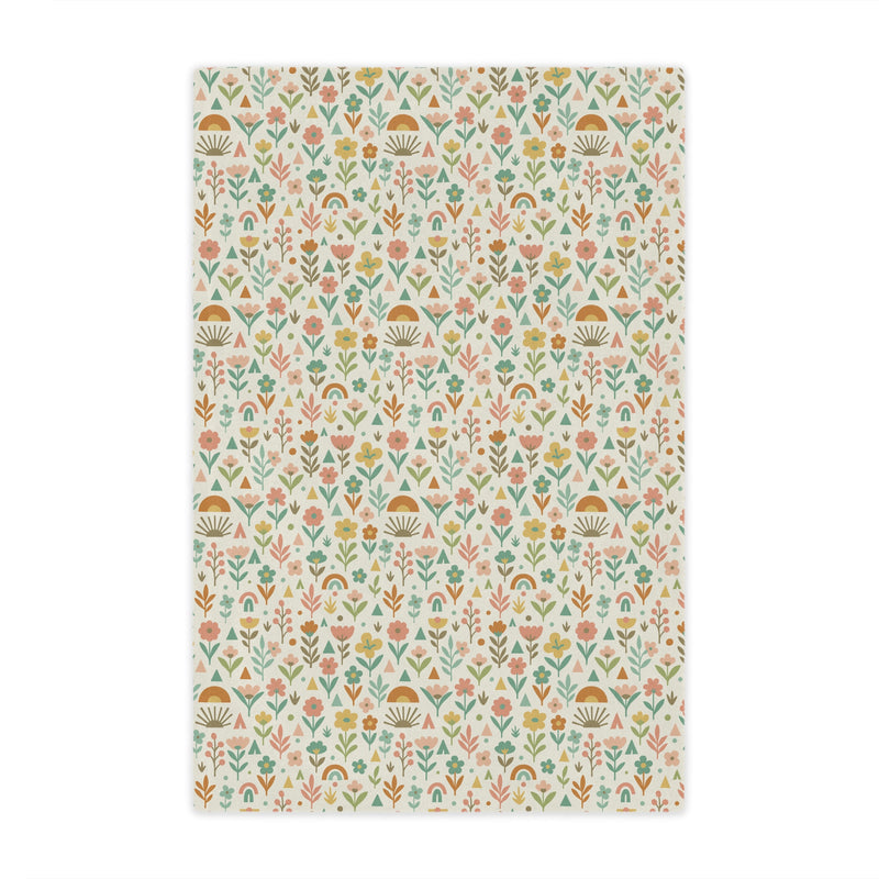 Patterned fabric with small floral and geometric designs on a light background