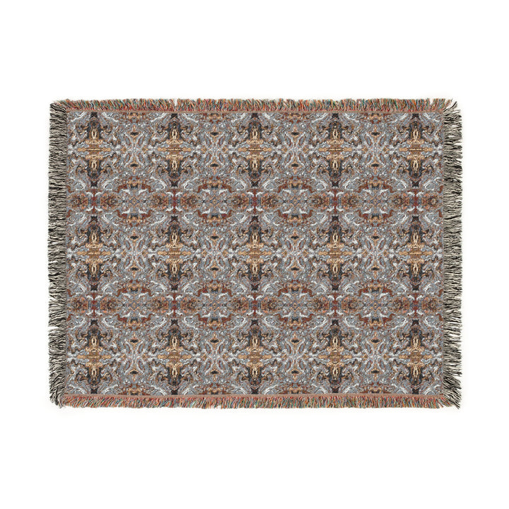 Patterned woven blanket with fringes on a white background
