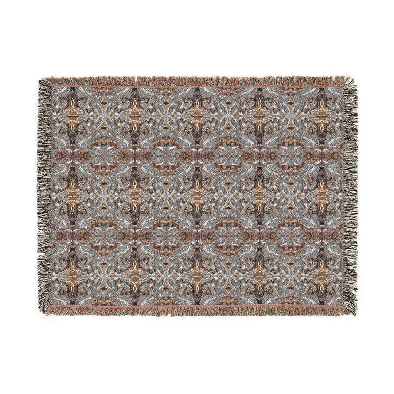 Patterned woven blanket with fringes on a white background