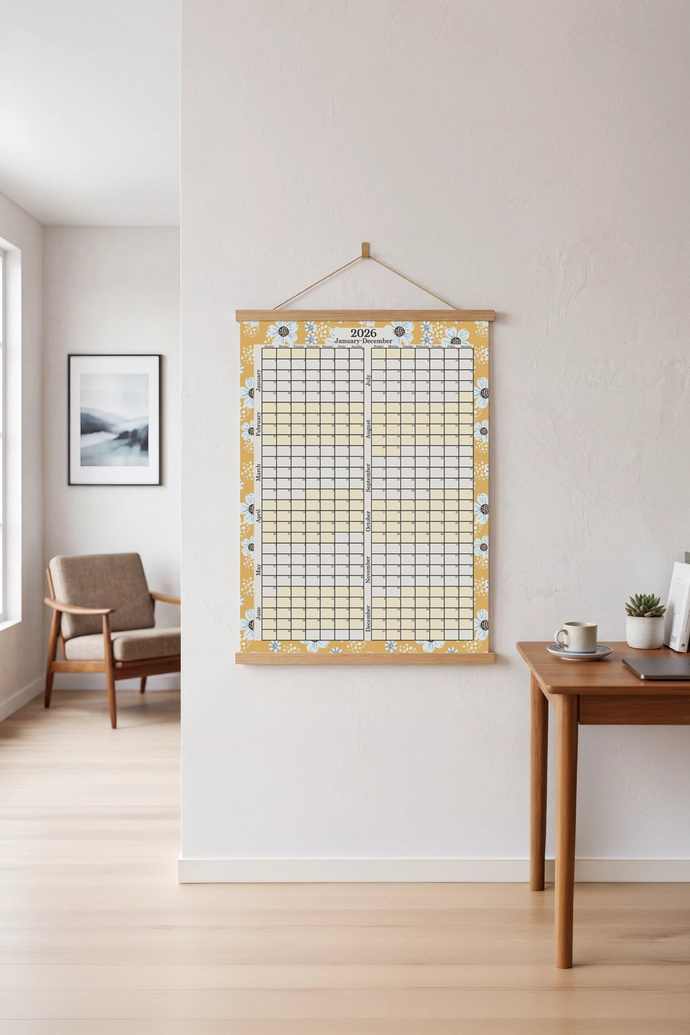 Wall-mounted calendar on a white wall in a room with a desk and chair.