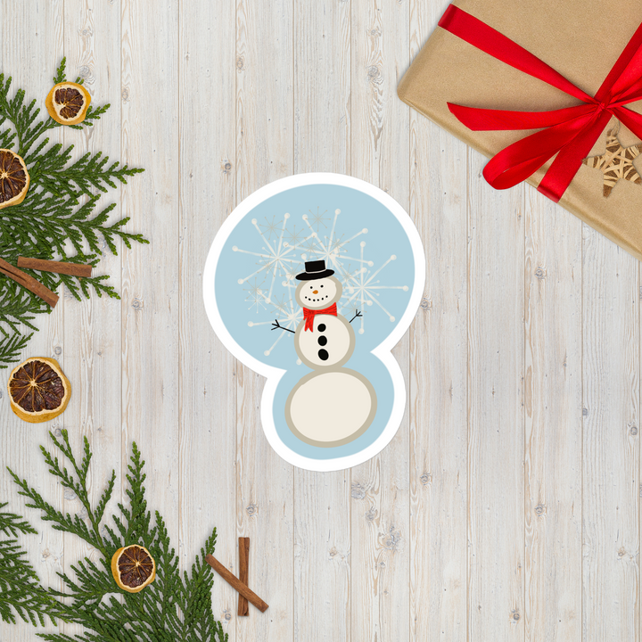 display of a snowman sticker that shows him in a red scarf and button down coal on his chest.  Snowflakes are also falling behind him.