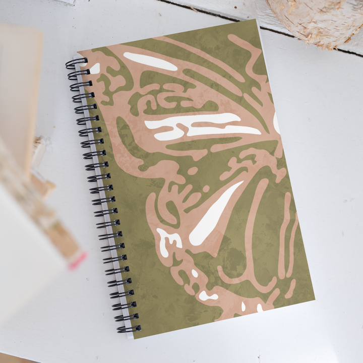 Picture of a green notebook with half of a coral colored butterfly with detailed wings.