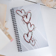 Chain link hearts with words around the design as the pattern on a notebook