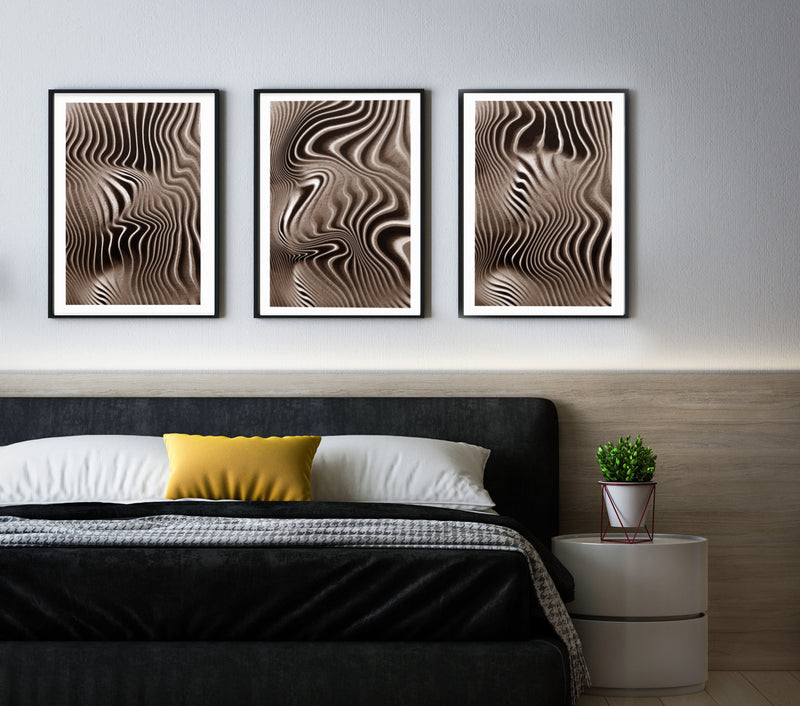 Picture of all three textured mushroom prints on a wall above a bed together.