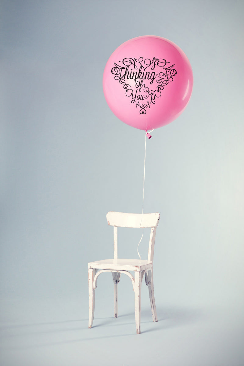 Product display of Thinking of you cut out for cutting machines. This product display shows the Cut out words Thinking of you cut out and placed on a balloon.  The balloon is attached to a chair.  Something cute to give as a gift or letting someone know that they are not forgotten.