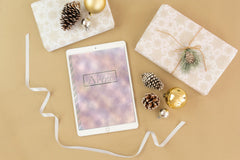 Digital Pink Watercolor Notebook on a table next to gifts and decorations displaying what it looks like on an ipad